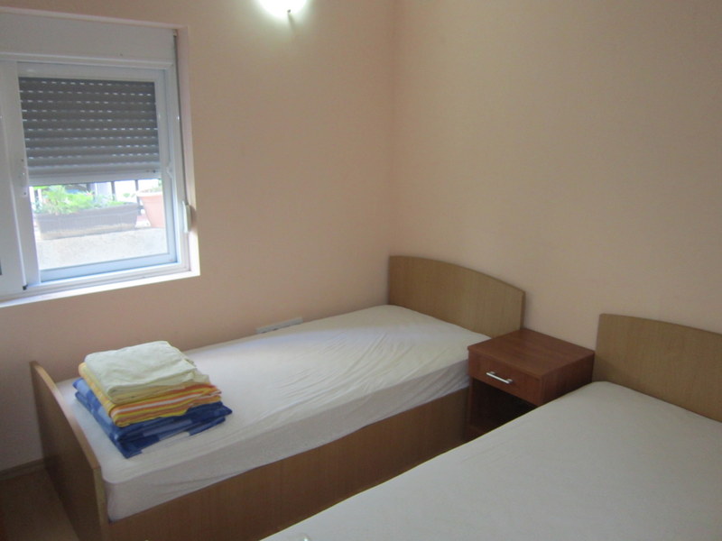 Bedroom with two single beds and a bedside table in a house for sale, Utjeha, Montenegro.