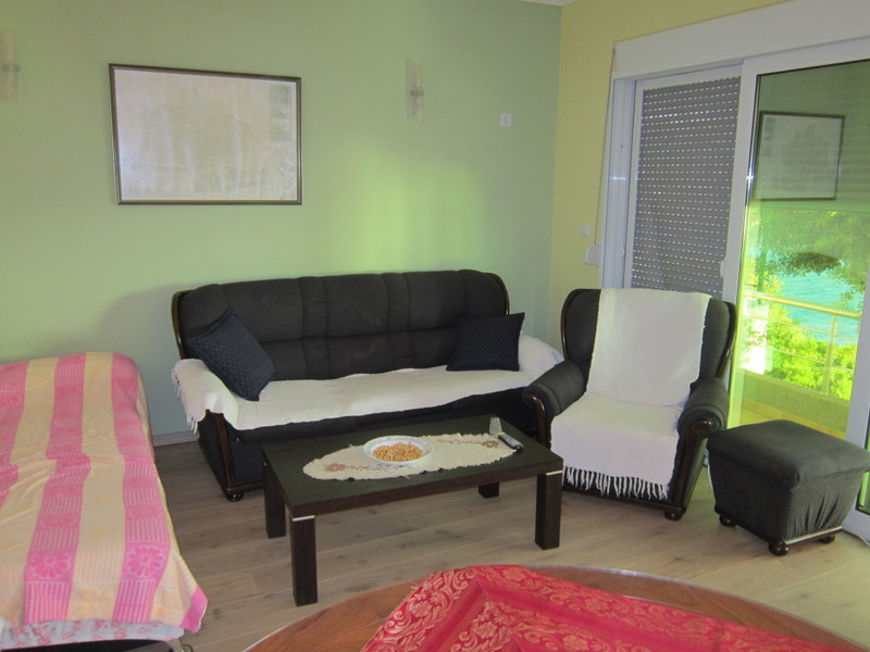Living room with soft furniture and access to a terrace with sea view in a house, Utjeha, Montenegro.
