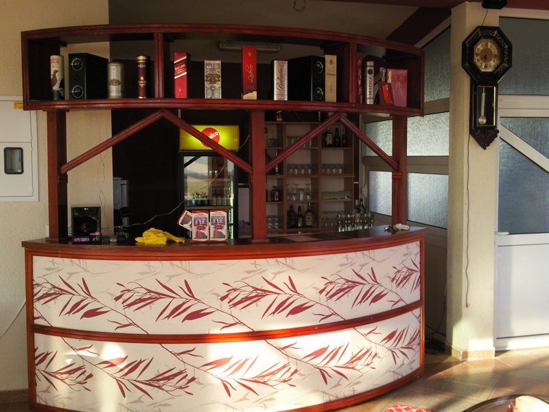 Wooden bar counter with drink shelves in a hotel interior in Bar, Montenegro.