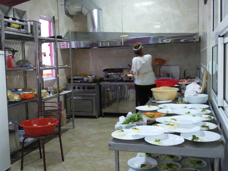 Professional hotel kitchen in Bar, Montenegro: stainless steel equipment, stove, hood, and work tables.