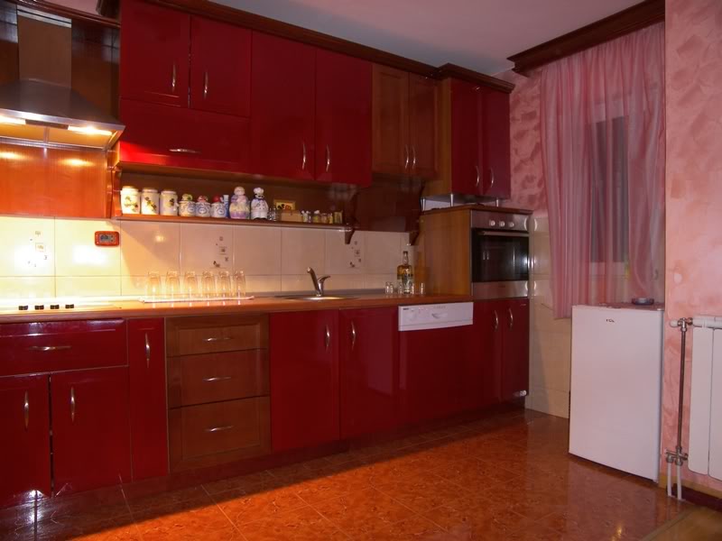 Kitchen with red glossy fronts and built-in appliances in a house for sale in Budva, Montenegro.