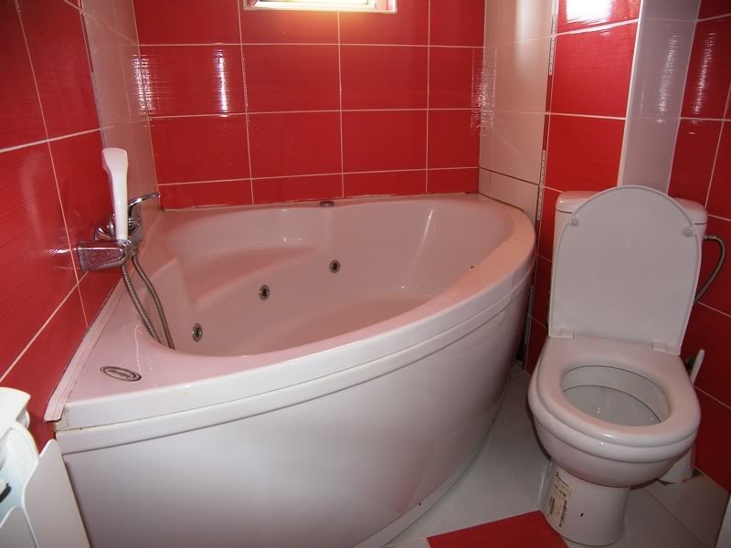 Bathroom with a corner whirlpool tub and red tiles in a house for sale, Budva, Montenegro.