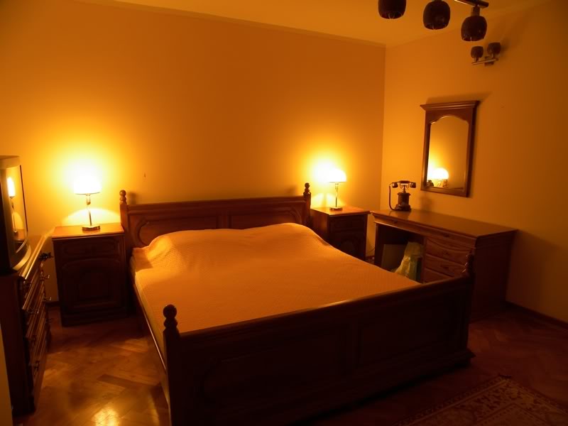 Cozy bedroom with classic wooden furniture in a house for sale in Budva, Montenegro: double bed and nightstands.
