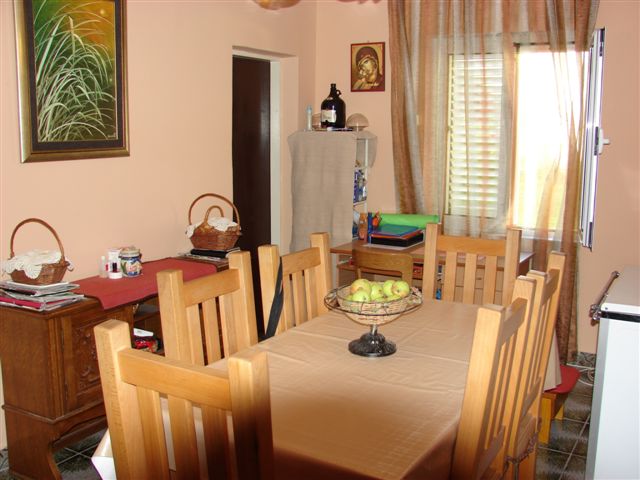Cozy living room with a wooden dining table in a house in Budva, Montenegro: interior with classic furniture.