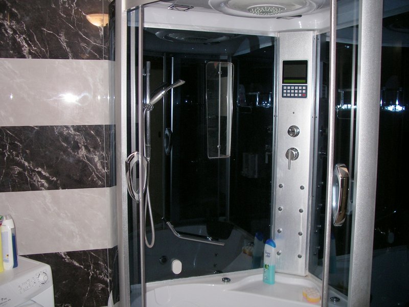 Modern shower cabin with hydromassage in the apartment bathroom in Rafailovići, Montenegro, tiled finish.