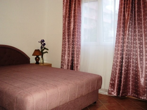 Cozy bedroom with a double bed and blackout curtains in a villa in Budva, Montenegro.