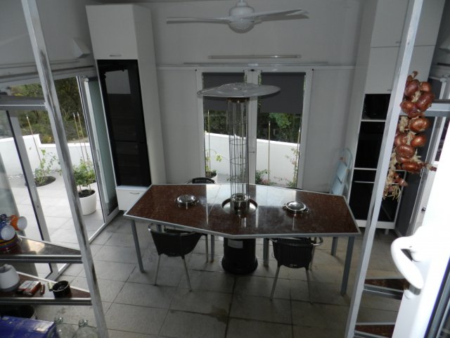 Living room with dining area and outdoor heater in a house, Bar, Montenegro, access to a terrace with a garden.