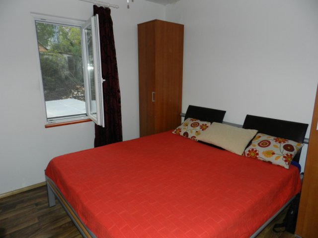 Bedroom with a double bed, wardrobe, and window in a house for sale in Bar, Montenegro.