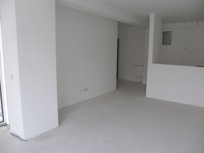 Living room in an unfinished apartment in Pržno, Montenegro: light walls, concrete floor, and a layout ready for renovation.