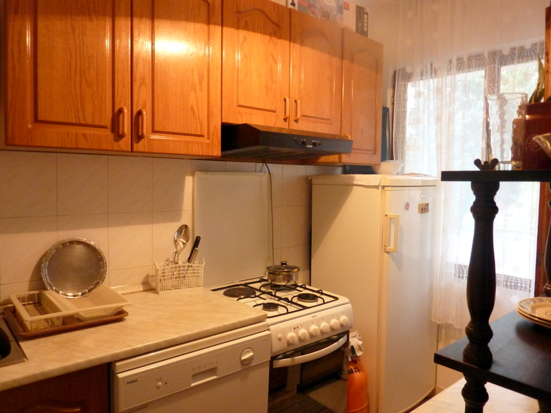 Kitchen with wooden cabinets, stove, and appliances in a house for sale, Sutomore, Montenegro.