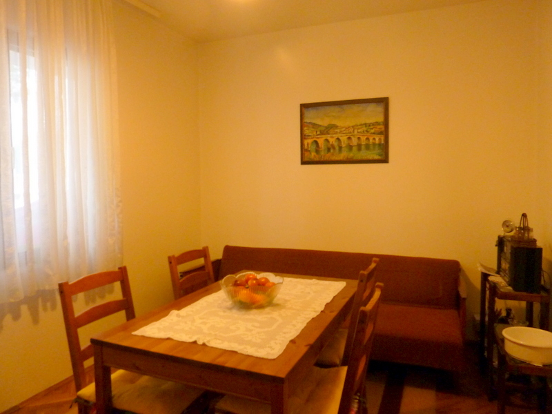 Cozy living room with a dining table and sofa in a house for sale in Sutomore, Montenegro.
