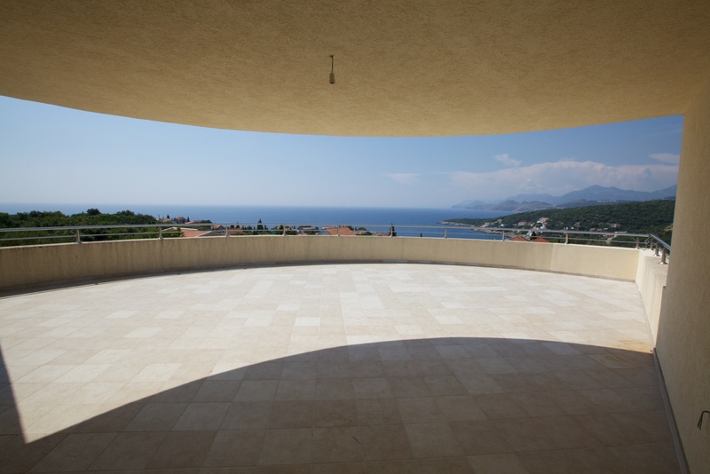 Spacious terrace with panoramic sea views in a house, Utjeha, Montenegro. Light tiles and metal railing.