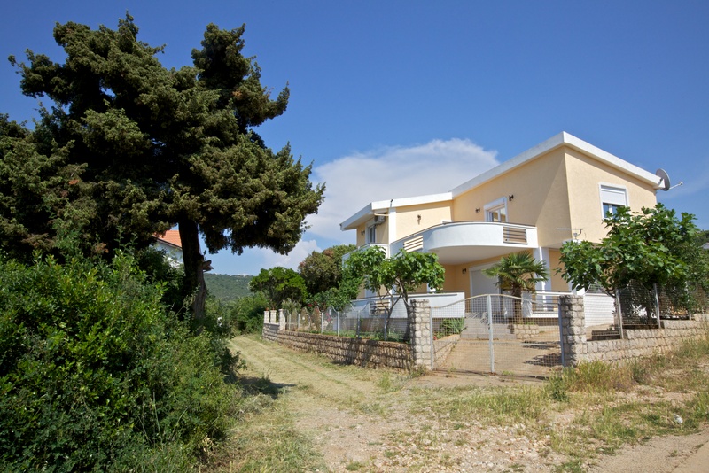 Two-story house with a terrace and garden in Utjeha, Montenegro: front view of a private villa with a fenced yard.