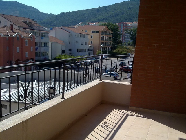 Open balcony with wrought-iron railing and views of the mountains and the city of Budva, Montenegro, in apartment No. 348.