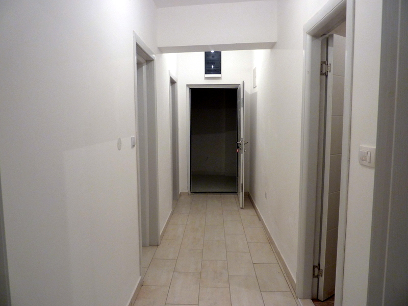 Bright hallway in an apartment in Becici, Montenegro: white walls, tiled floor, and modern interior doors.
