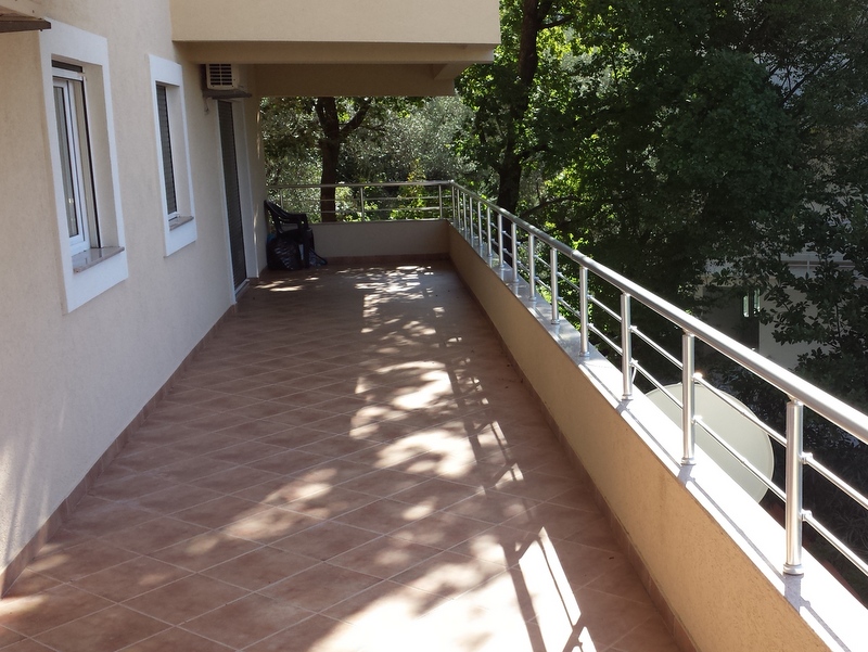 Spacious balcony with tiled floor and metal railing in an apartment, Pržno, Montenegro.