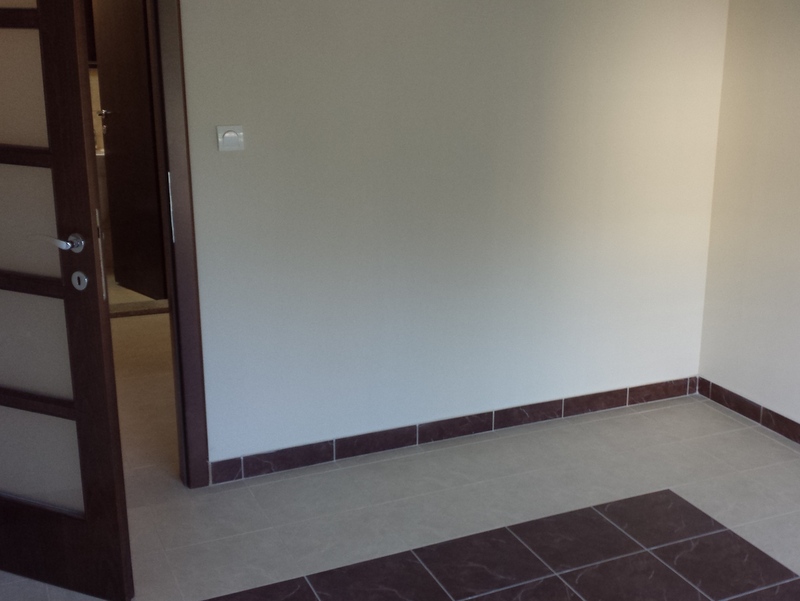 Bright living room in an apartment in Pržno, Montenegro: tiled floor with decorative pattern, interior door with frosted glass.