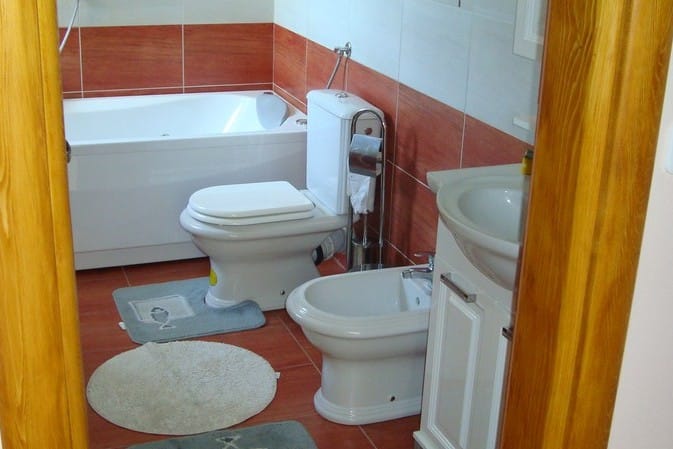 Bathroom in a hotel in Čanj, Montenegro: white fixtures, bidet, bathtub, and red-and-white tile finishes.
