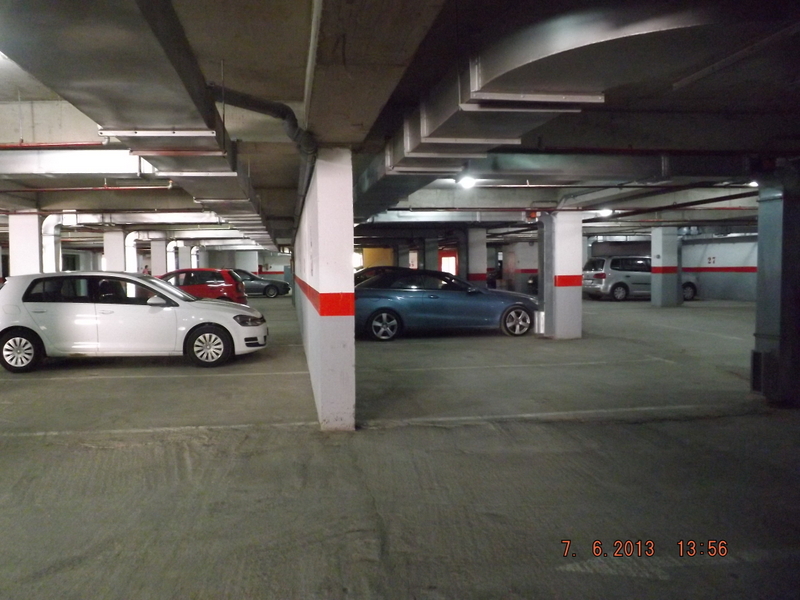 Covered underground parking in a residential complex in Pržno, Montenegro: concrete columns, ventilation, and parking spaces.
