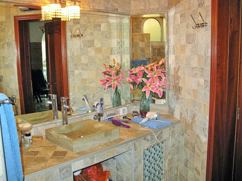 Bathroom with natural stone finishes in a villa in Dobra Voda, Montenegro: stone sink and mirror.