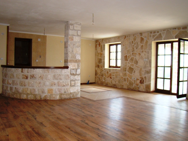 Living room in a house in Petrovac, Montenegro: natural stone finishes, a bar counter, and wooden flooring in the interior.
