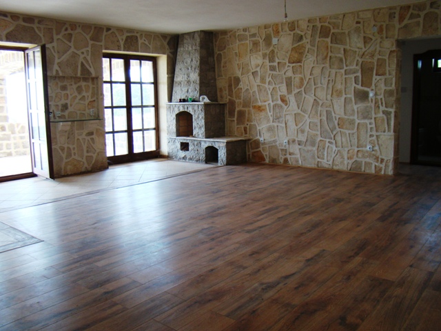 Living room in a house in Petrovac, Montenegro: a spacious room with natural stone wall finishes and a fireplace.