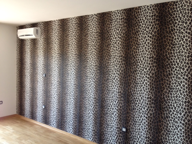 Living room interior in an apartment in Budva, Montenegro: an accent wall with leopard print and a wall-mounted air conditioner.