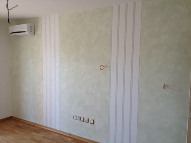 Living room in an apartment in Budva, Montenegro, with decorative plaster and wallpaper on the walls and an installed air conditioner.