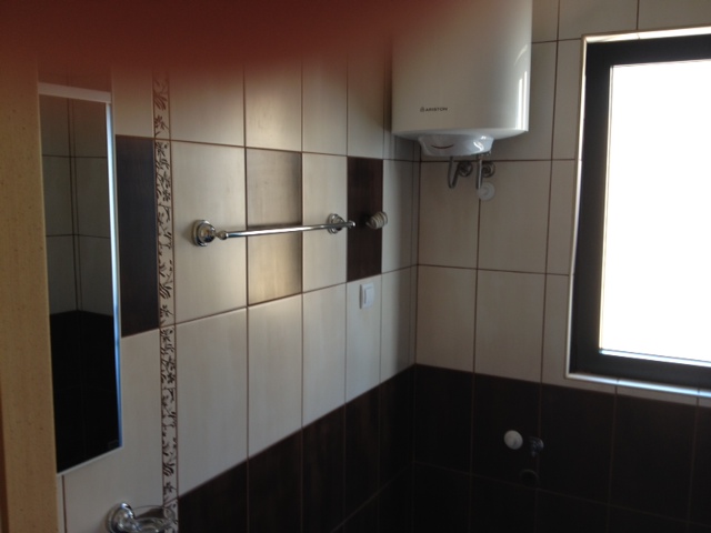 Bathroom with an Ariston boiler and tiled finish in an apartment in Budva, Montenegro.