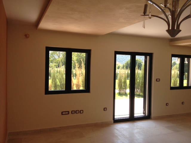 Bright living room in an apartment in Budva, Montenegro: panoramic windows, modern finishes, and a designer chandelier.