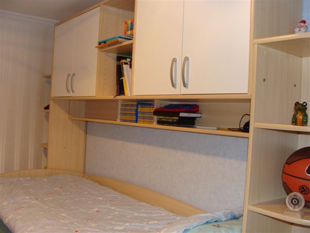 Children's bedroom with a bed and built-in light-colored wardrobe in an apartment in Budva, Montenegro.