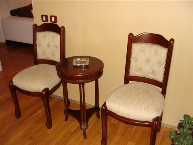 Two classic wooden chairs and a round table in the interior of an apartment in Budva, Montenegro.