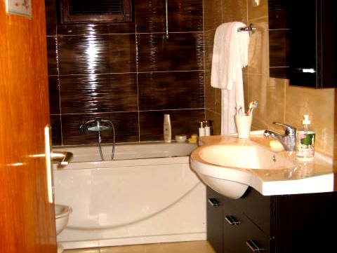 Modern bathroom with dark tiles and white fixtures in a house in Herceg Novi, Montenegro.
