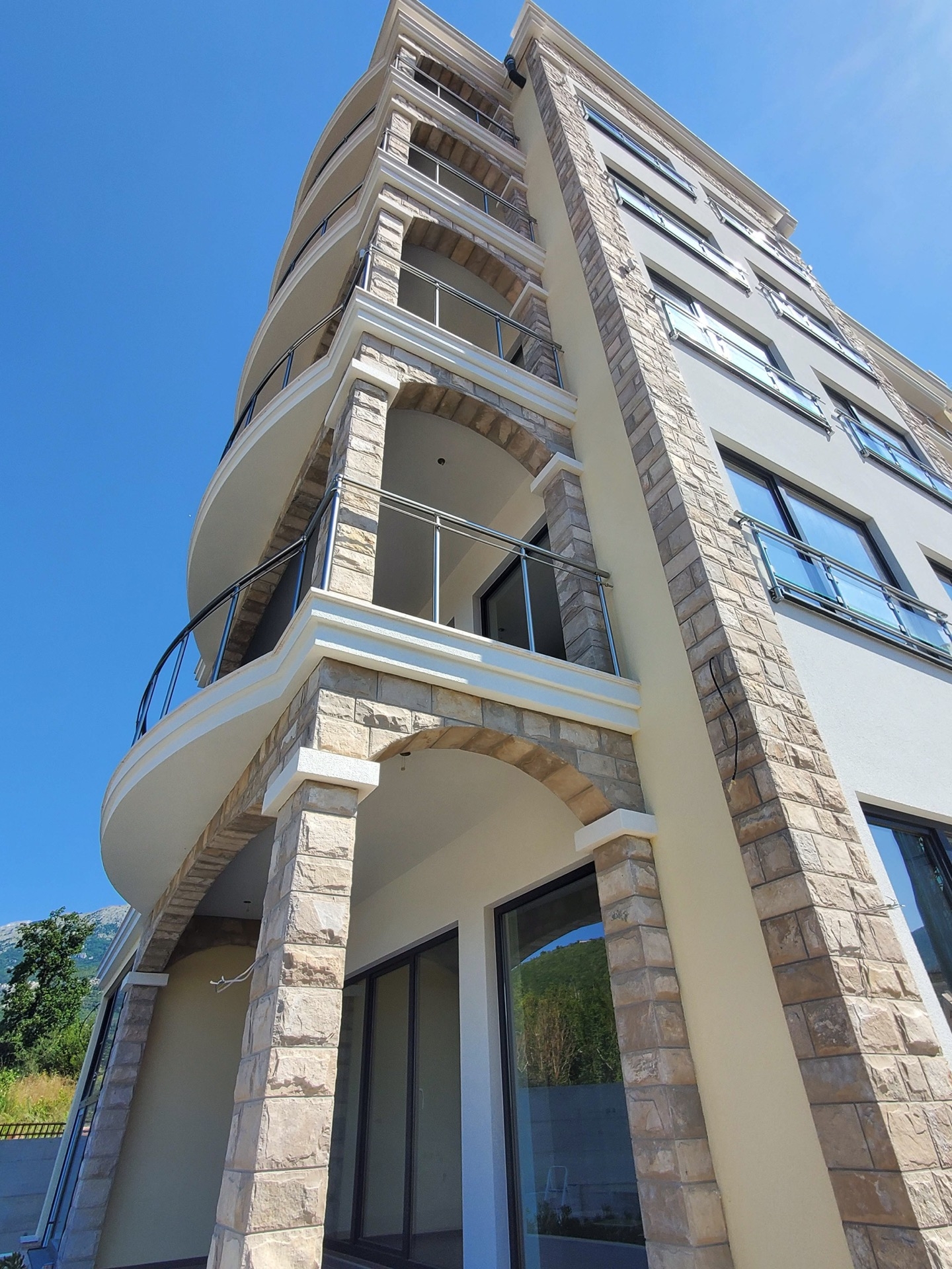 Modern MonteDreams residential complex in Bečići, Montenegro: facade with stone cladding and panoramic balconies.
