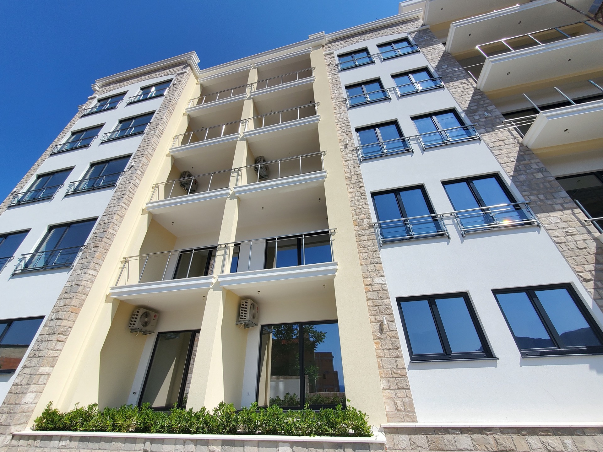 Modern residential complex MonteDreams in Becici, Budva Riviera, Montenegro: facade with balconies and stone cladding.