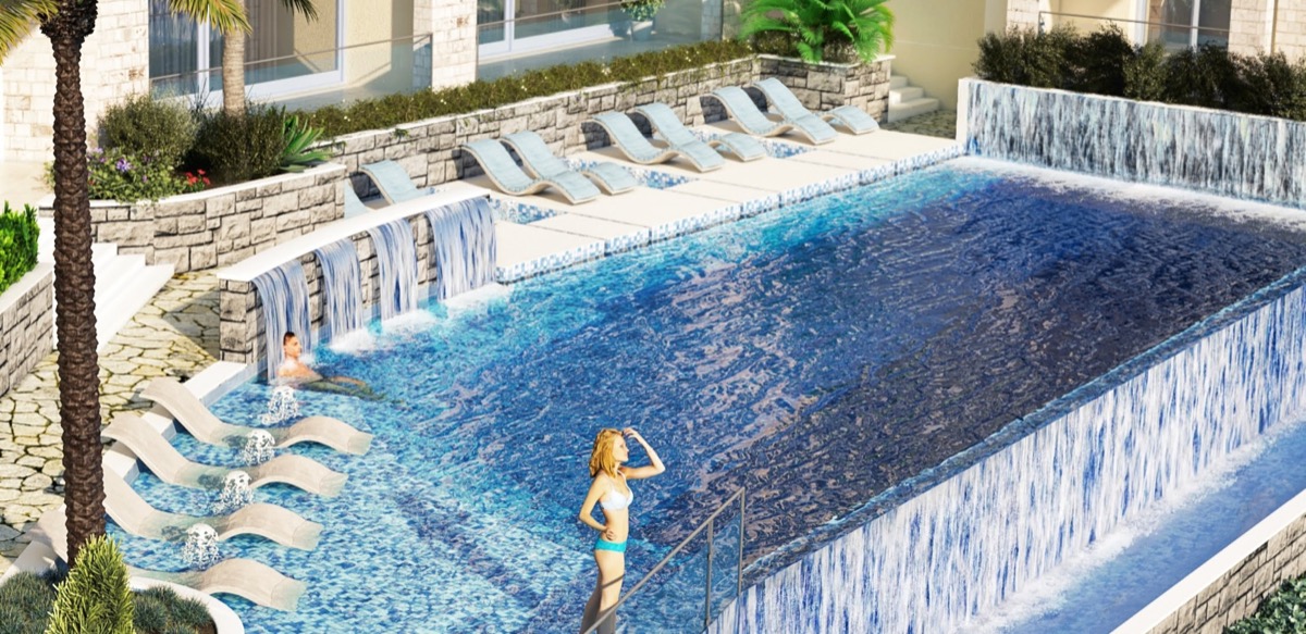 Open-air pool with waterfalls and sun loungers in the MonteDreams residential complex, Becici, Budva Riviera, Montenegro.