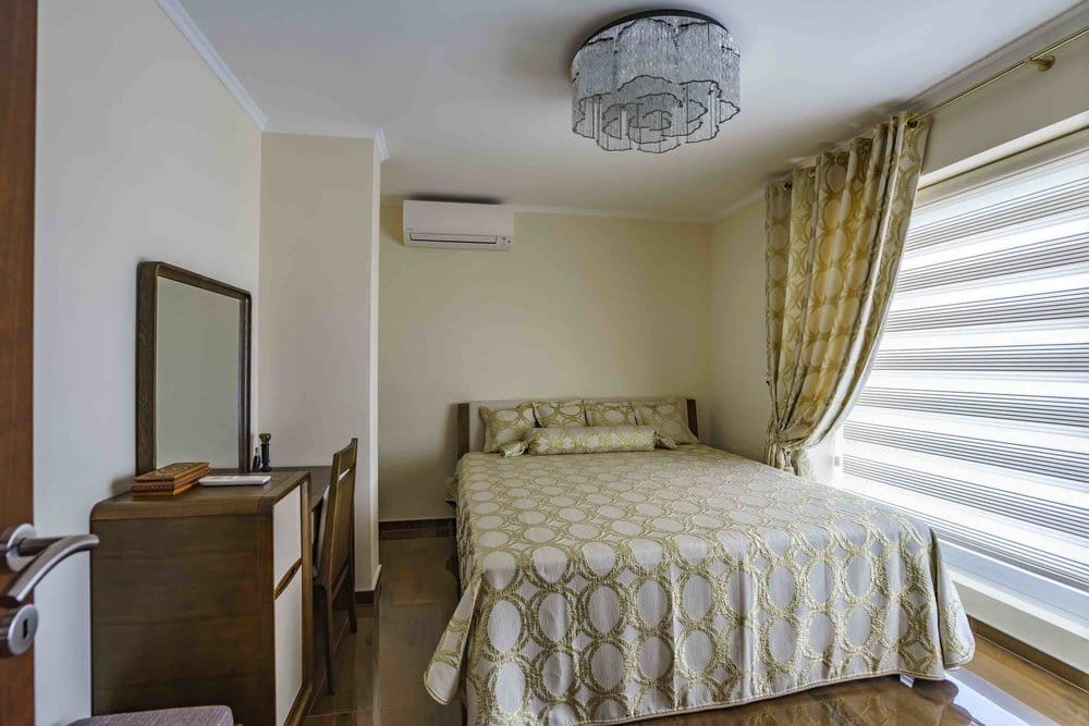 Cozy bedroom with a double bed and vanity table in a villa in Seoce, Montenegro. Modern interior.