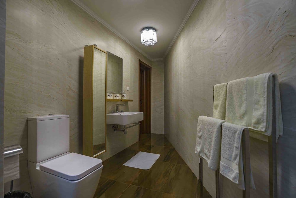 Modern bathroom with light stone finishes in a villa in Seoce, Montenegro: fixtures and towel warmer.