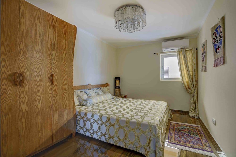 Bedroom with a double bed and a wooden wardrobe in a villa in Seoce, Montenegro. Cozy interior with air conditioning.