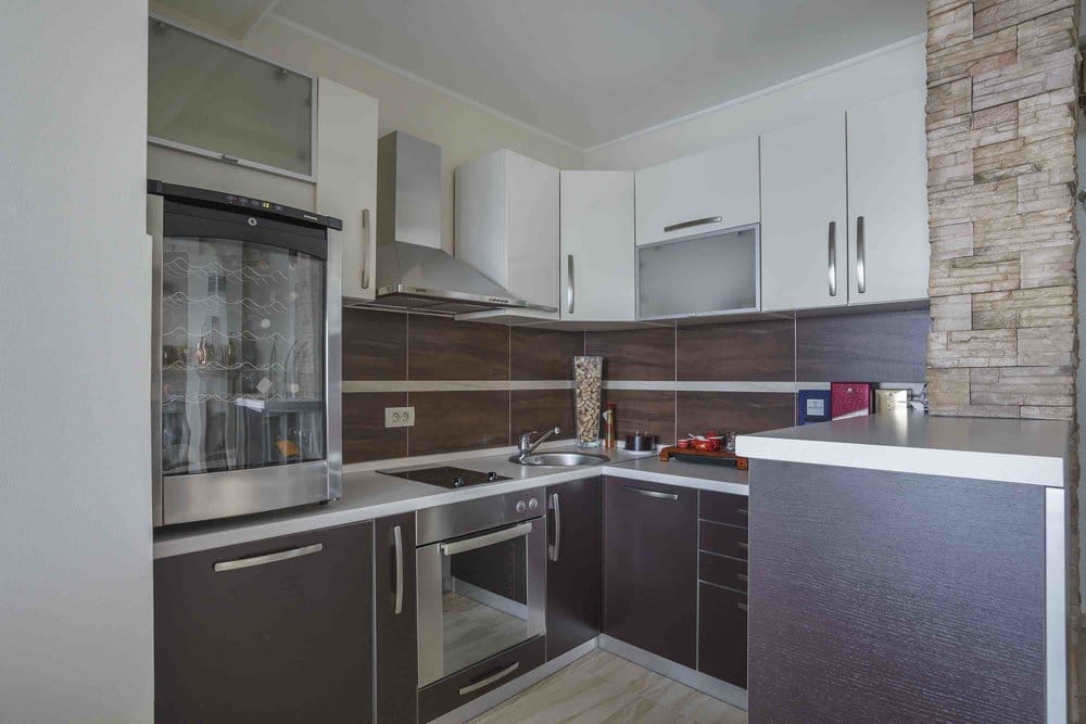 Modern kitchen with a wine cooler and stone finishes in a villa in Seoce, Montenegro: stylish interior and appliances.