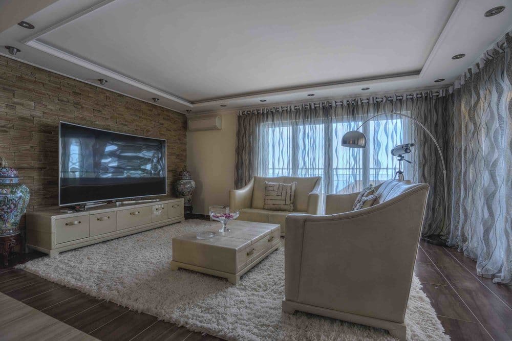Living room in a villa in Sutomore, Montenegro: light furniture, stone finishes, panoramic windows, and a cozy interior.