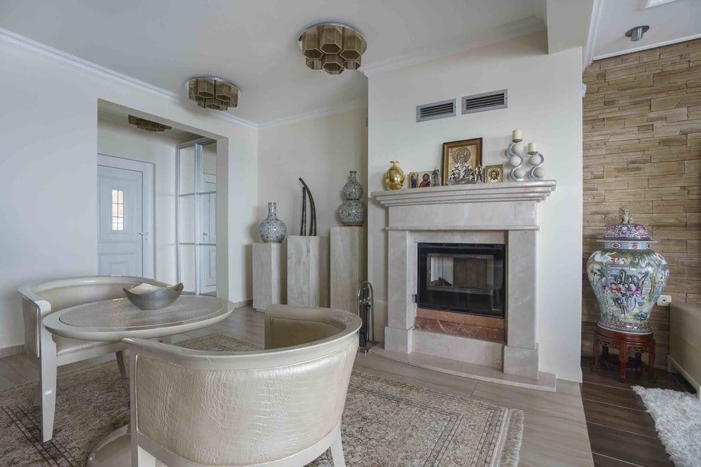 Living room with a fireplace and classic furniture in a villa in Seoce, Montenegro: a stylish interior with stone finishes.