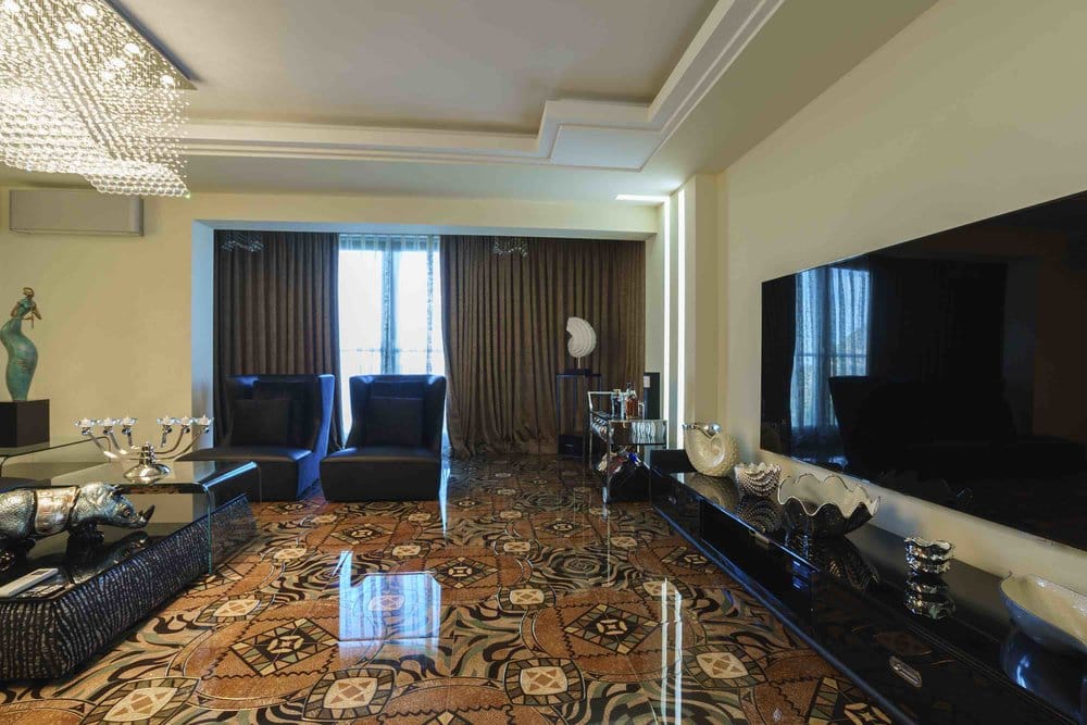 Luxurious living room with designer flooring and a crystal chandelier in a villa in Sutomore, Montenegro. Modern interior.