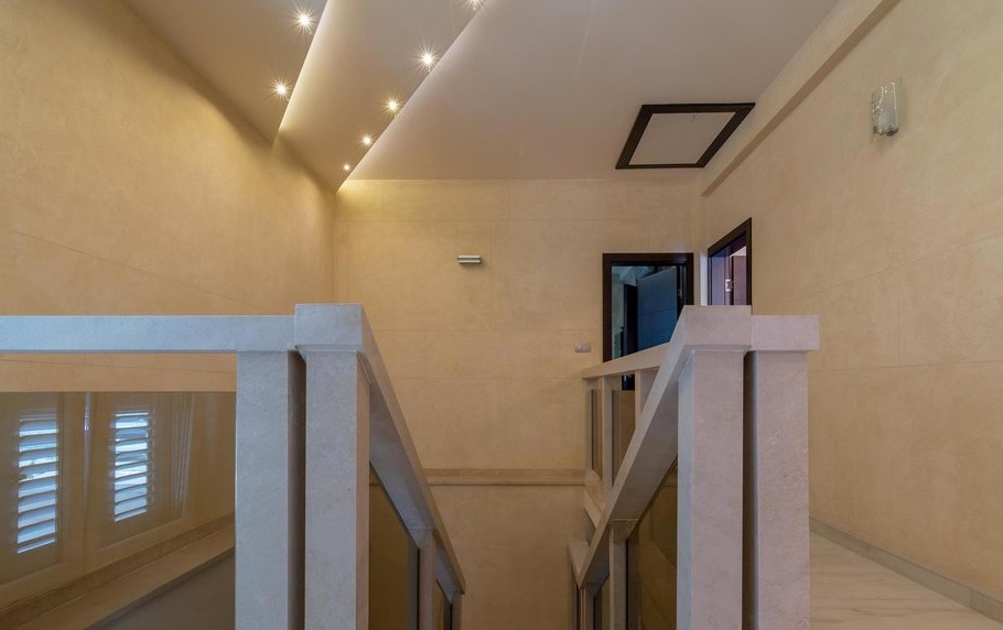 Modern staircase with stone railings and spot lighting in the interior of a villa in Tivat, Montenegro.