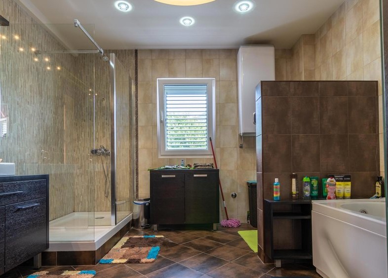 Modern bathroom with a shower cabin and bathtub in a villa in Tivat, Montenegro, with high-quality tiled finishes.