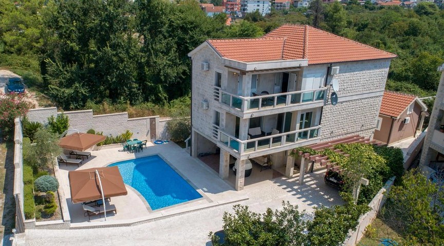 Three-story villa in Tivat, Montenegro, with a private pool, terraces, a lounge area, and on-site parking.