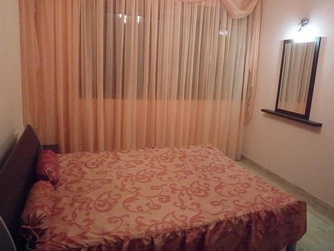 Cozy bedroom with a double bed in a house, Zelenika, Montenegro: light curtains, a mirror, and a classic interior.