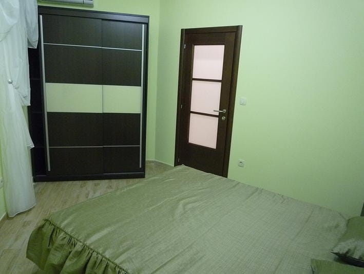 Bedroom in a house in Zelenika, Montenegro: double bed, dark sliding wardrobe, and interior door.