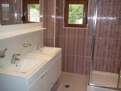 Bathroom with two sinks and a shower cabin in a house, Zelenika, Montenegro. Modern tile finish.