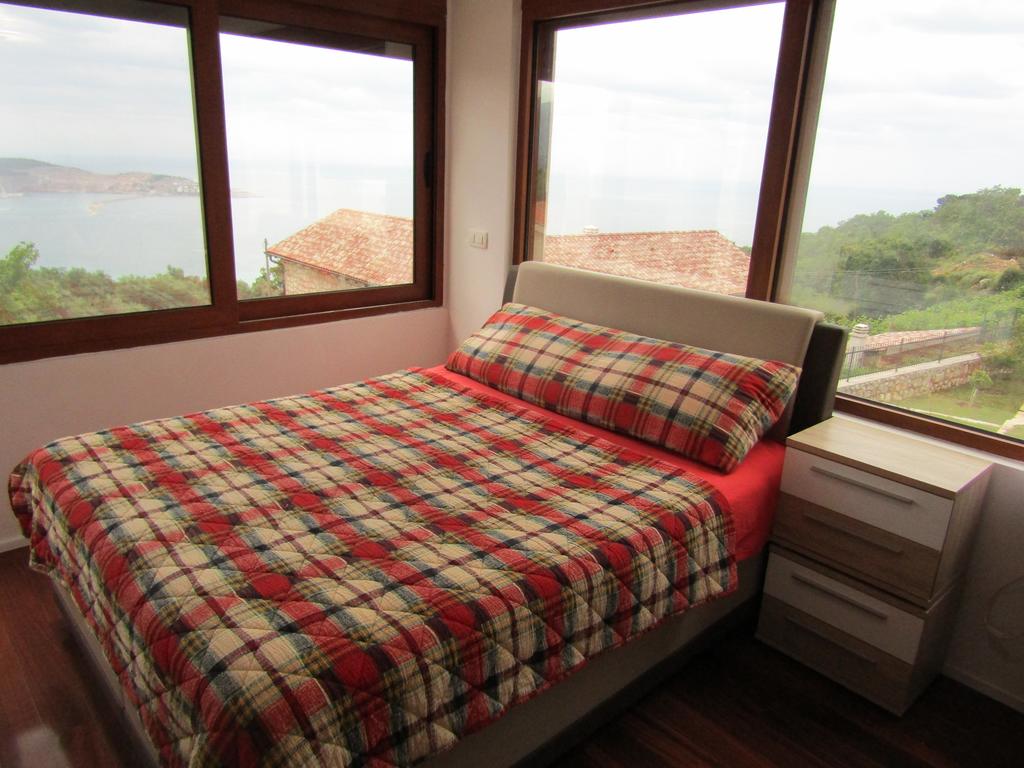 Bedroom with panoramic sea view in a house, Shushan, Bar Riviera, Montenegro: double bed and wooden floor.